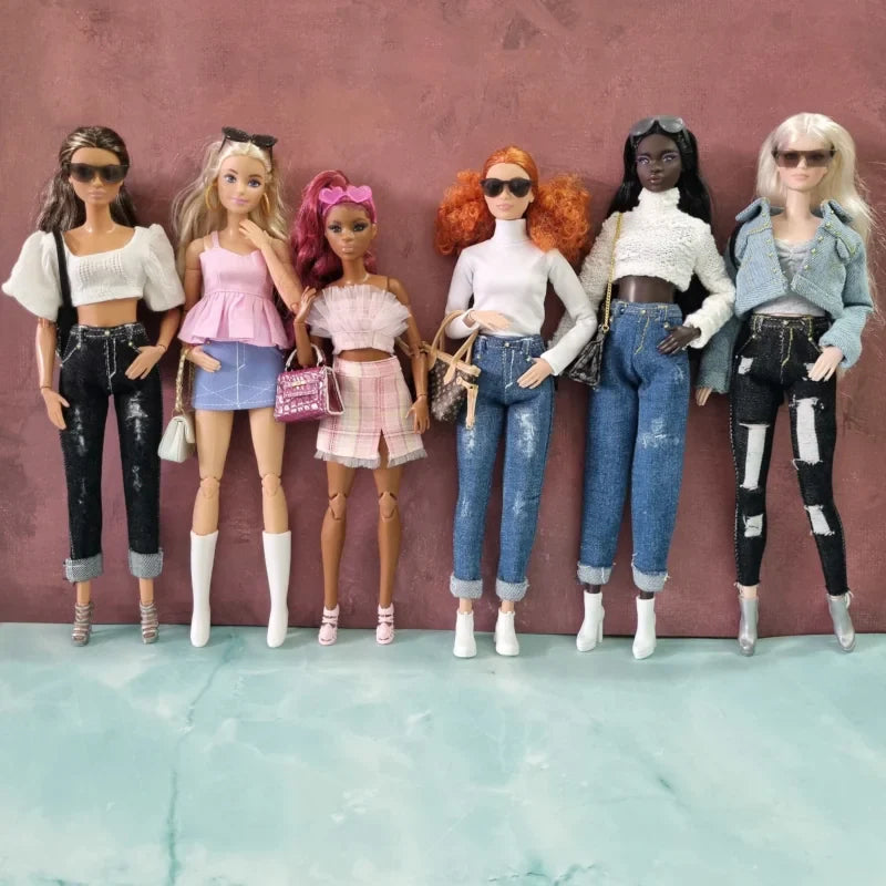 Shop stylish doll clothes for Barbie: Collection of modern outfits including distressed jeans, crop tops, skirts, and accessories modeled by six diverse dolls.
