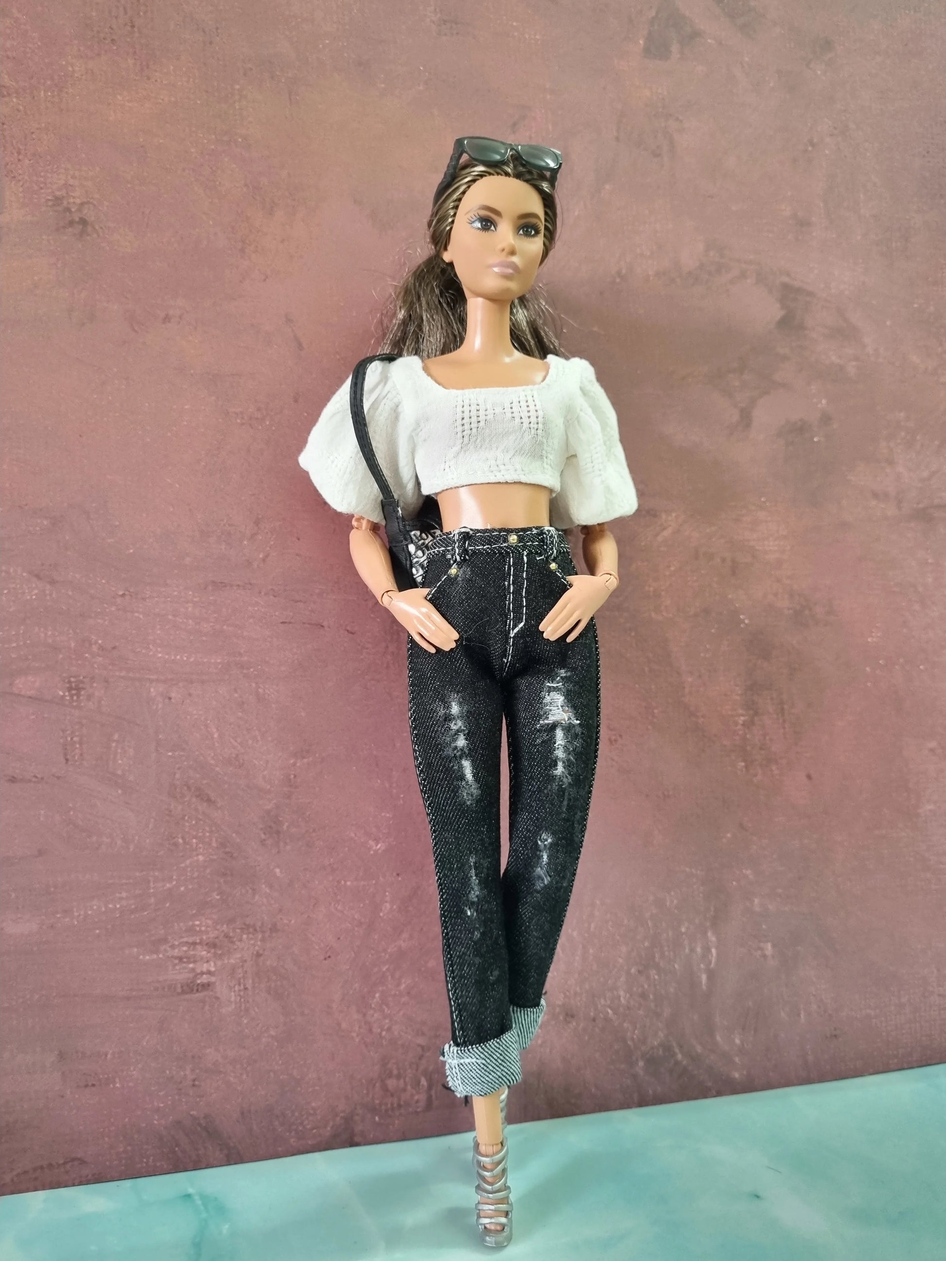 Trendy Barbie doll outfit featuring a white puff sleeve top and distressed black cuffed jeans.