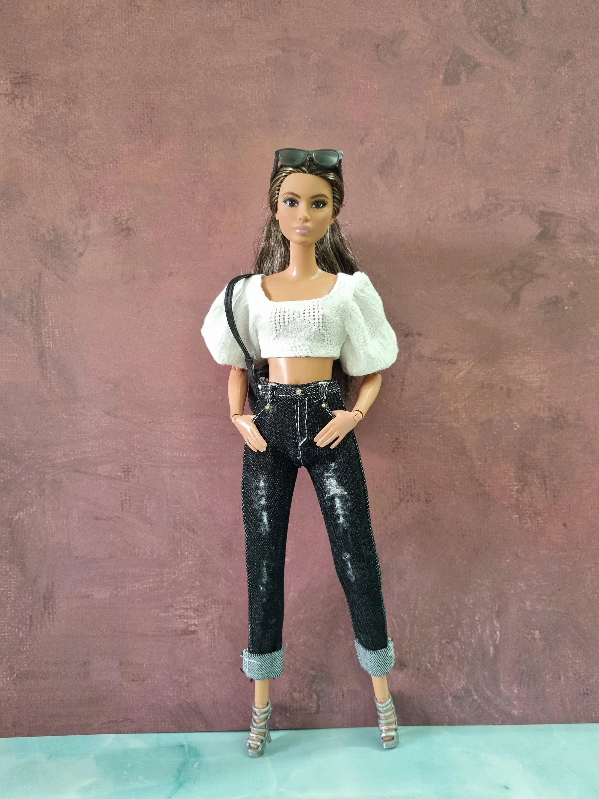 Barbie doll wearing stylish casual outfit: white textured top and black distressed cuffed jeans