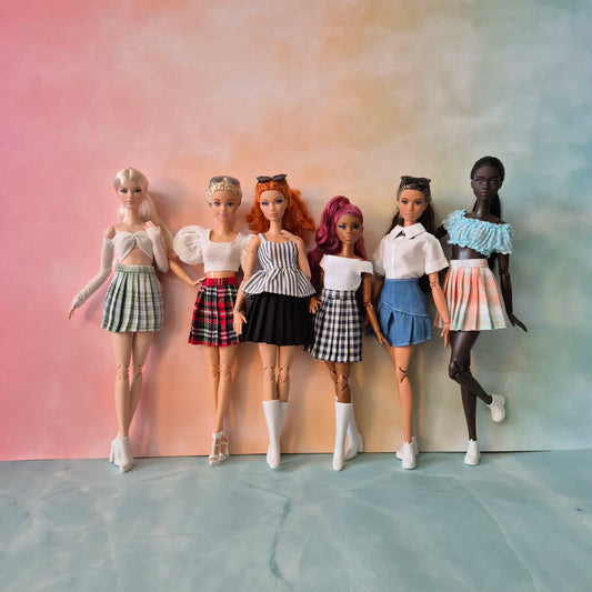 Group of six diverse Barbie dolls showcasing various preppy skirt and crop top outfits.