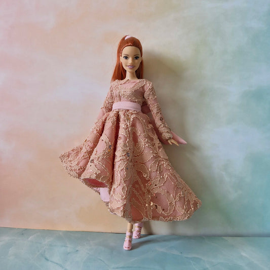Barbie Curvy doll posing elegantly in dusty rose gold sequin lace dress showing the movement of the high-low skirt.