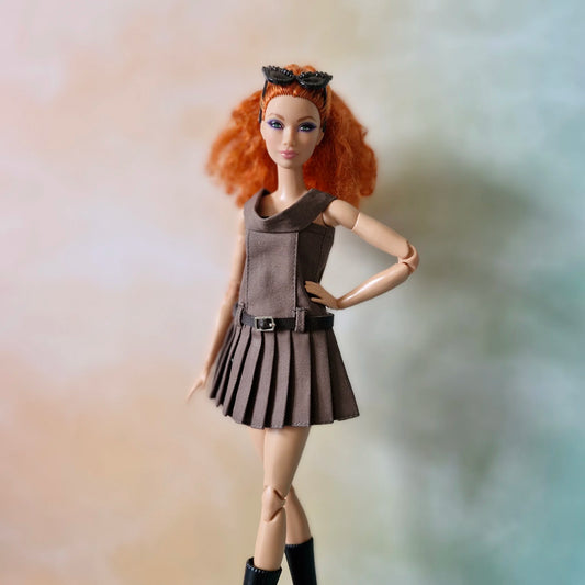 Close-up of redhead Barbie doll in brown off-shoulder pleated dress with hand on hip
