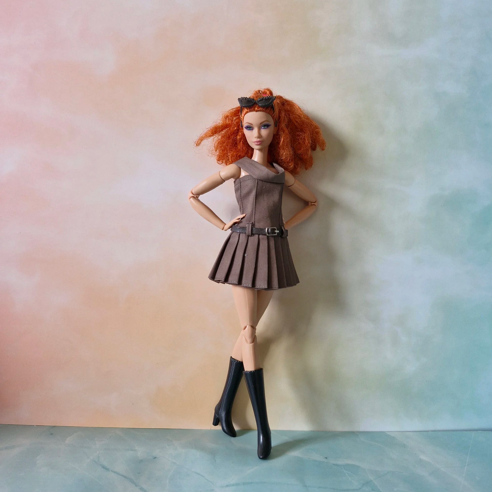 Full view of redhead Barbie doll in brown off-shoulder dress with hands on hips