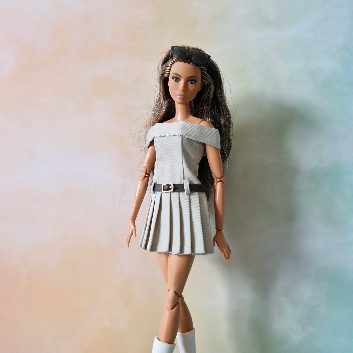 BarbieBarbie doll wearing grey off-shoulder pleated dress with belt, sunglasses on head, and white boots doll wearing grey off-shoulder pleated dress with belt, sunglasses on head, and white boots