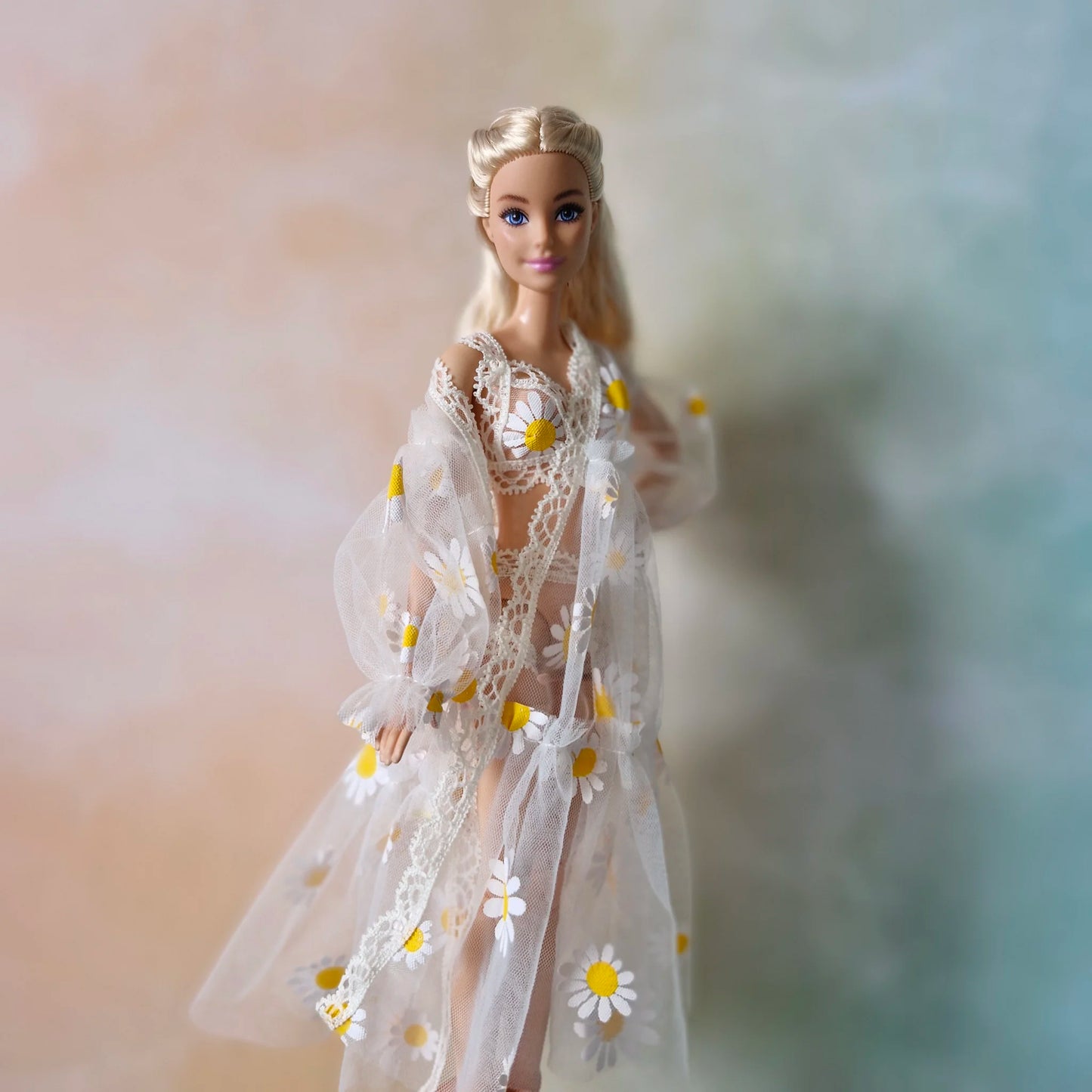 Blonde Barbie doll wearing sheer white daisy print robe over bikini, angled view