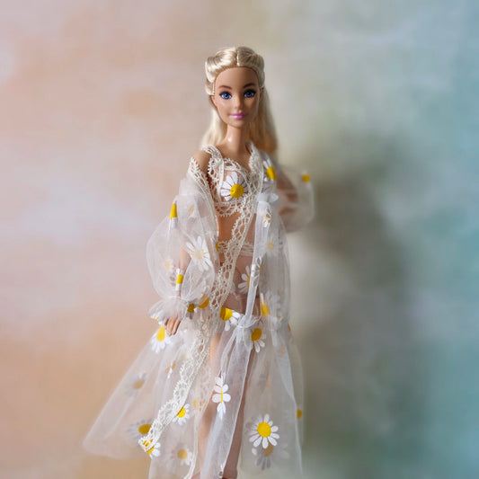 Blonde Barbie doll wearing sheer white daisy print robe over bikini, angled view