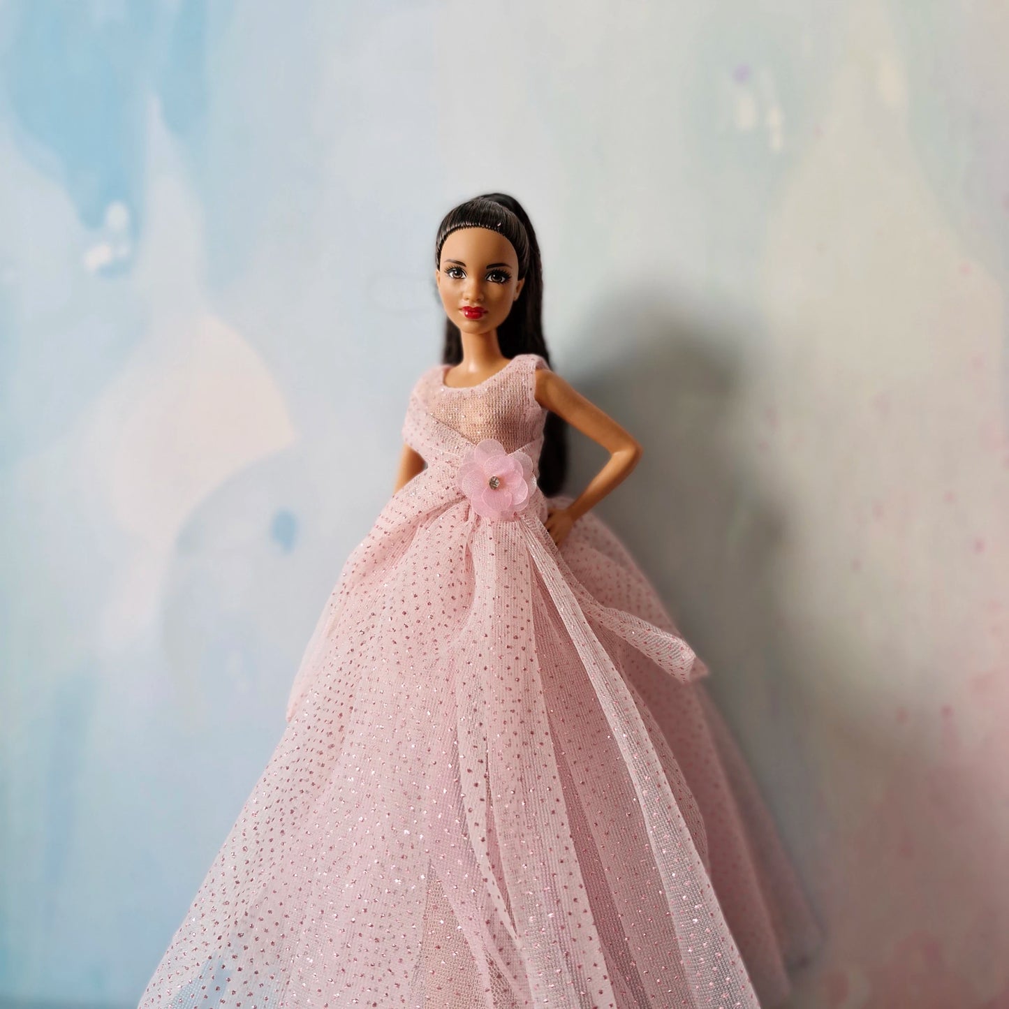 Barbie doll modeling elegant pink glitter tulle ball gown, medium shot front view.