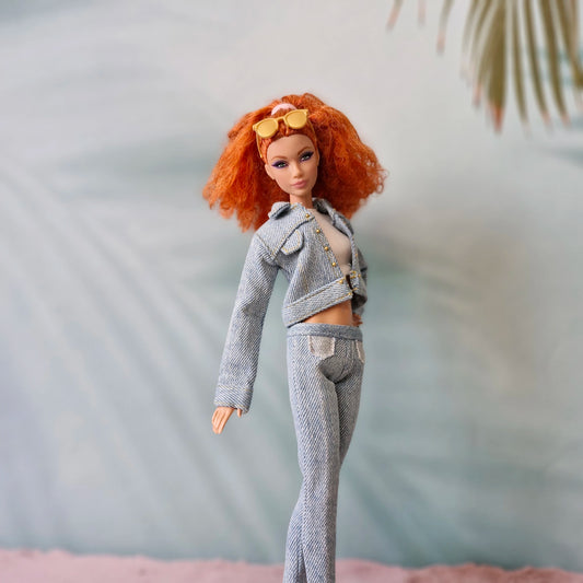 Barbie doll with red hair in light wash denim jacket and jeans set, orange sunglasses.