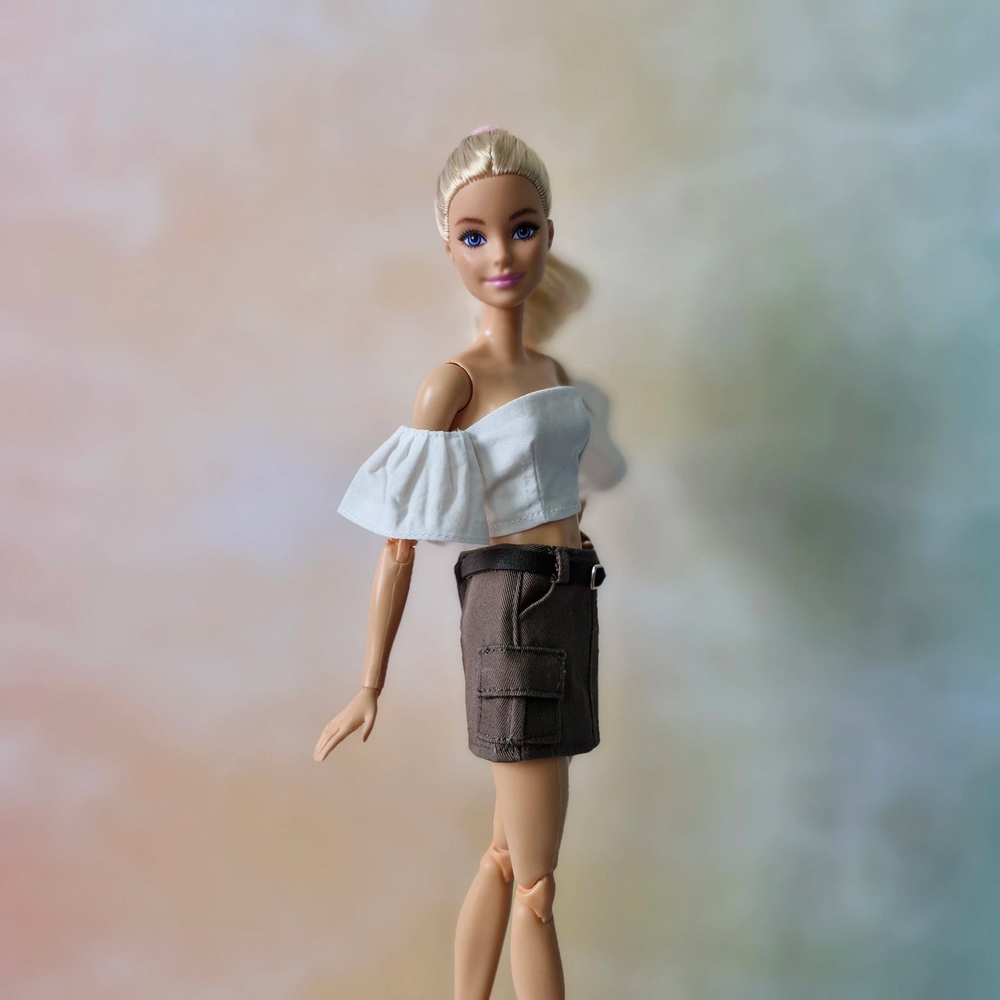 Barbie doll in chic white off-shoulder crop top and brown cargo skirt, casual style.