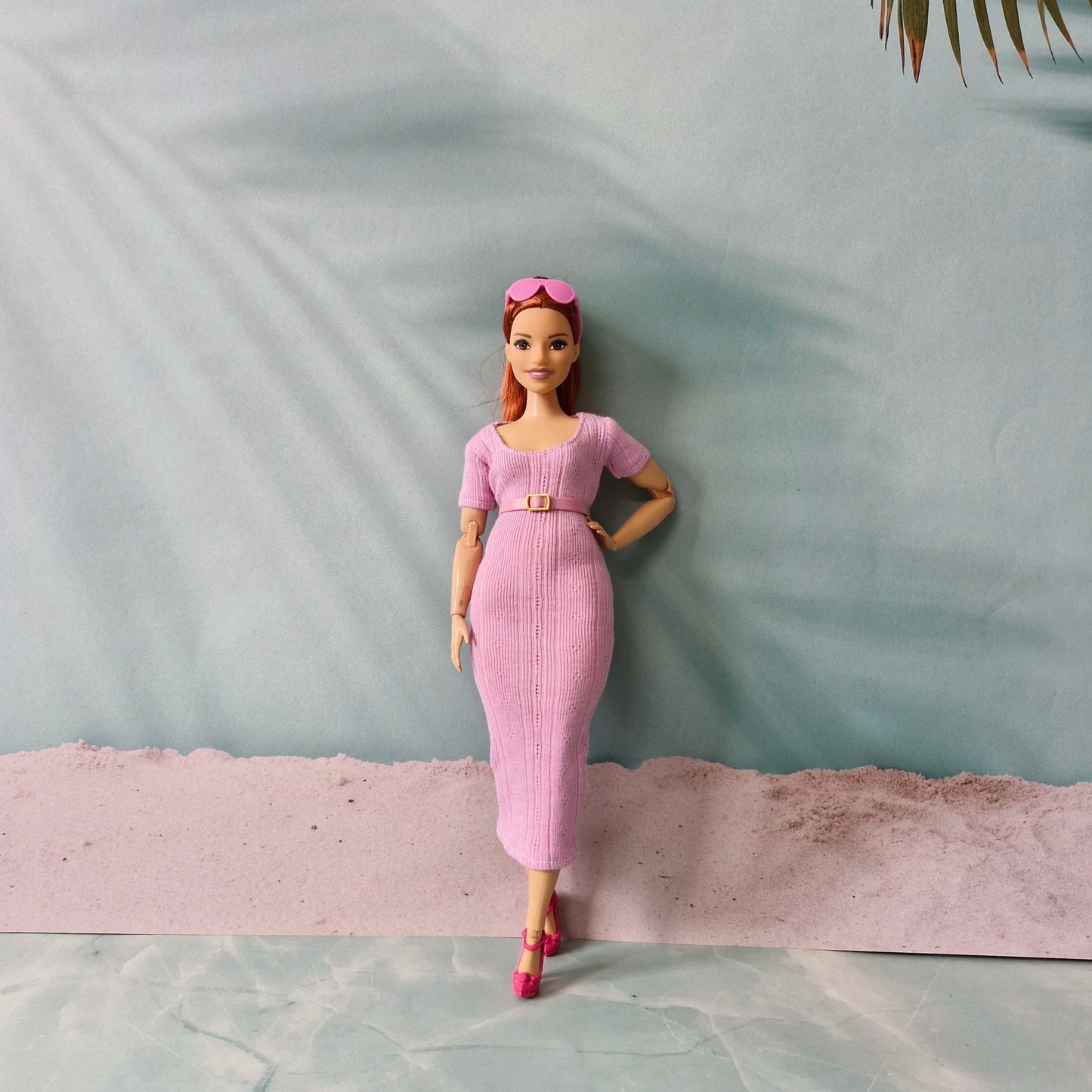 Barbie doll in pink ribbed midi dress styled with a matching pink belt and pink heels.