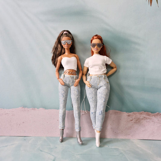 Curvy and standard Barbie dolls posing together wearing sunglasses with their white top and distressed jeans outfits.