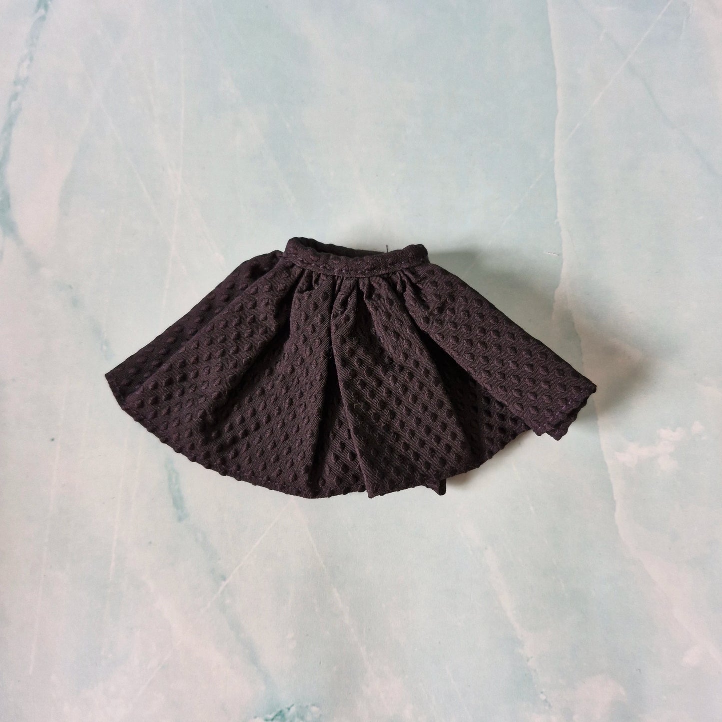 Brown textured skirt on a light marble background