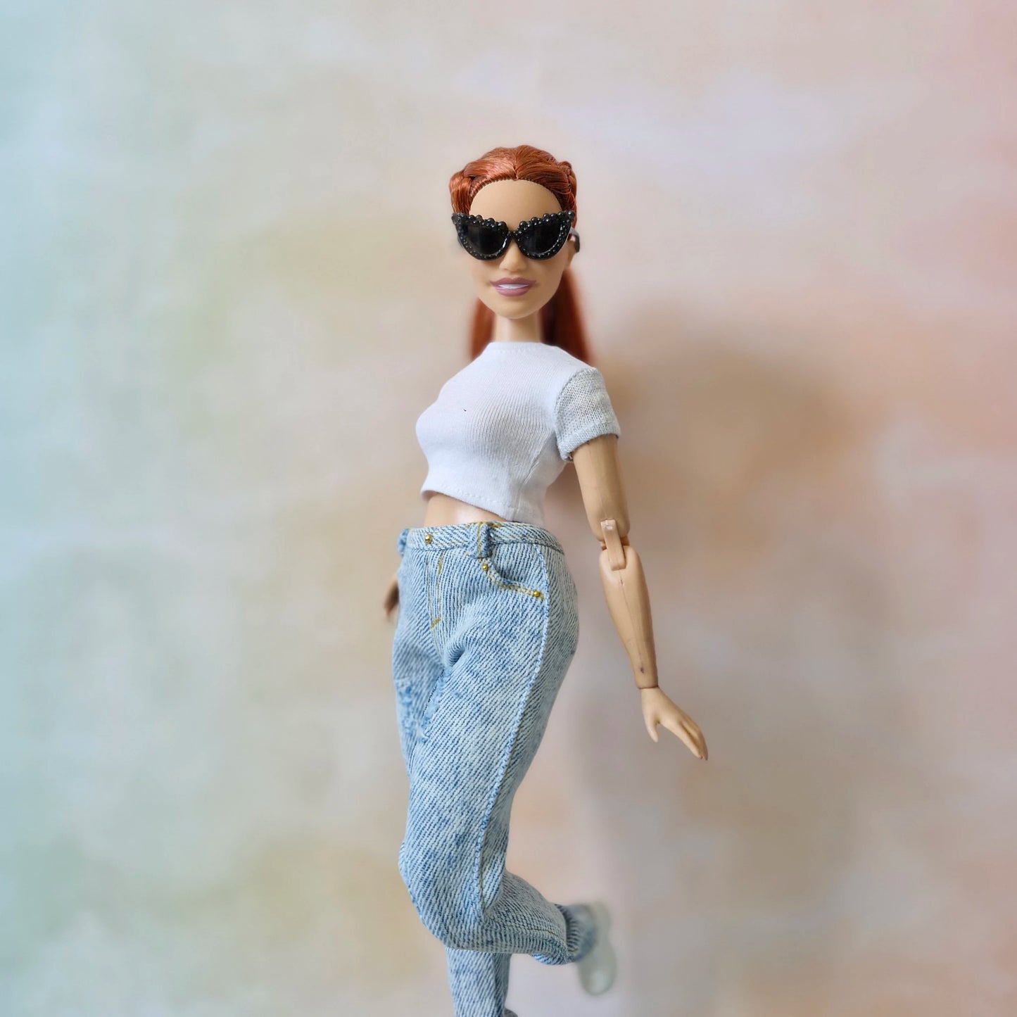 Curvy Barbie doll in white top and jeans with black studded sunglasses