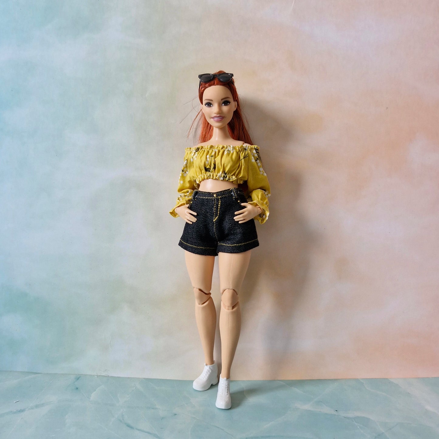 Curvy Barbie doll wearing the 'Summer Sunshine' outfit with a yellow floral top and black denim shorts.