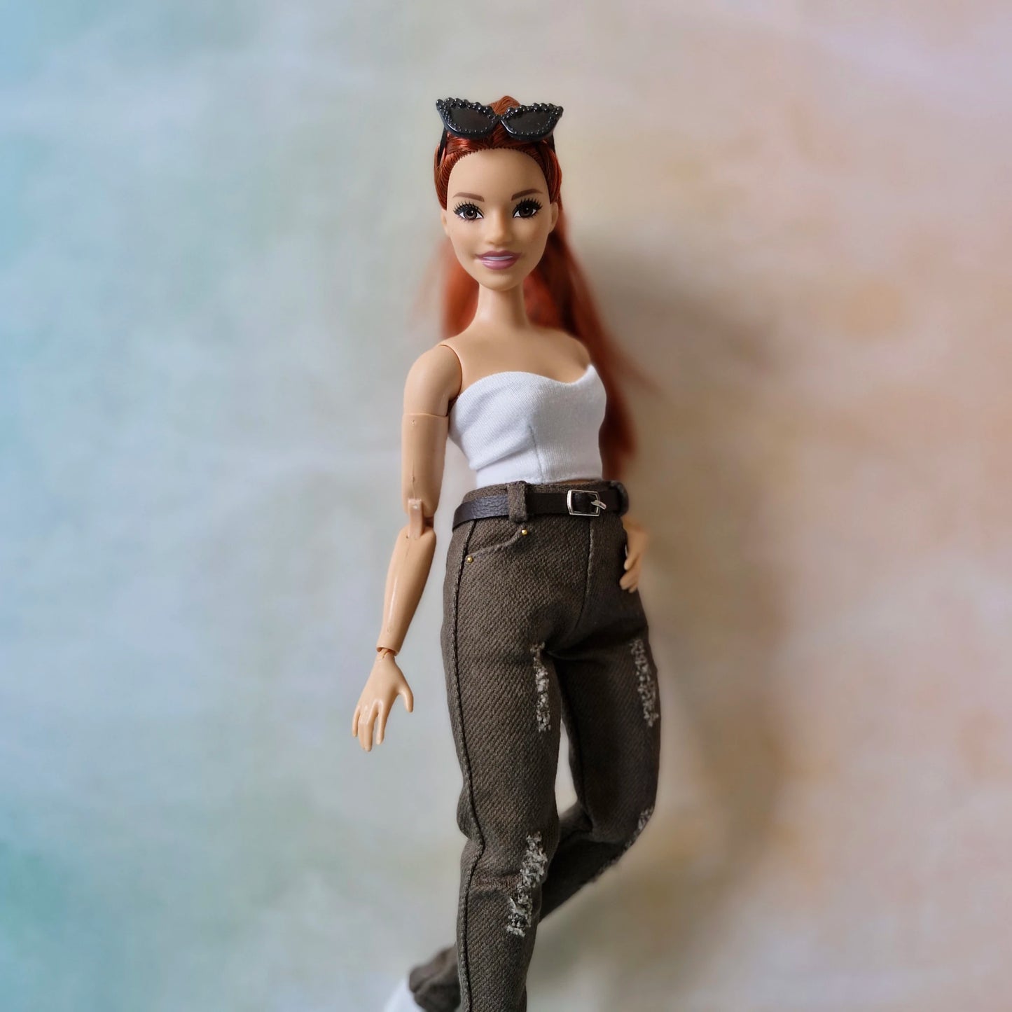 Curvy Barbie doll with red hair and a white top on a gradient background