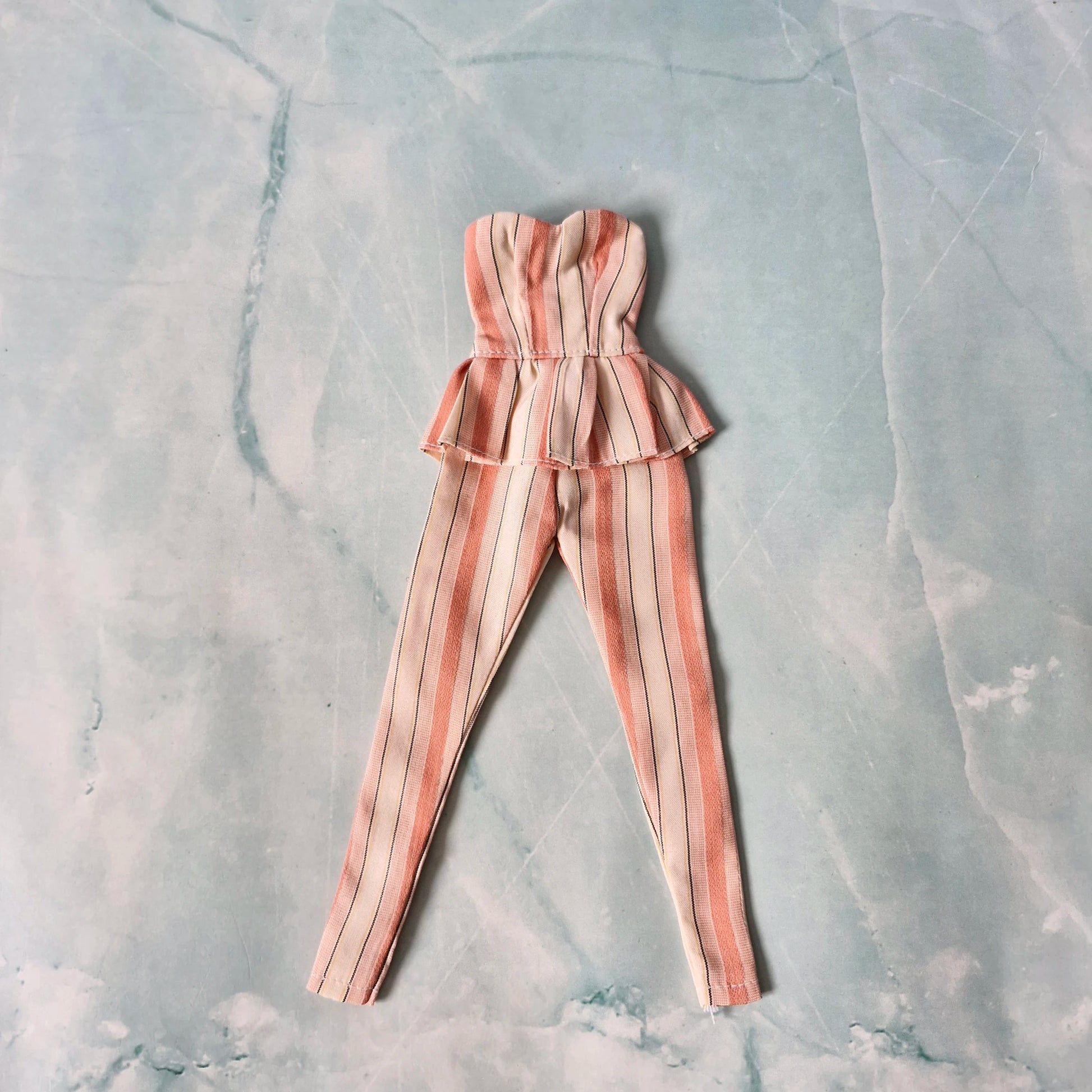 Striped romper on a textured gray background