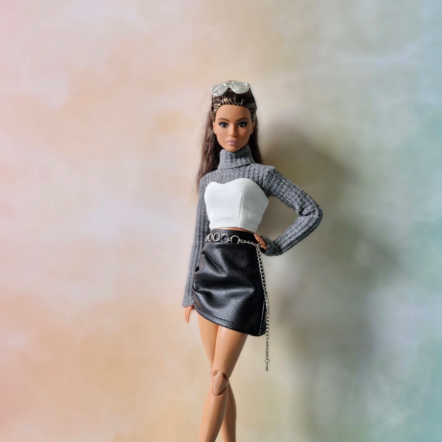 Close-up of Barbie wearing gray turtleneck sweater and black leather skirt