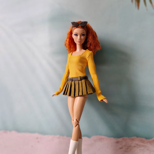 Redhead Barbie doll wearing mustard yellow long sleeve ribbed top and olive green pleated skirt