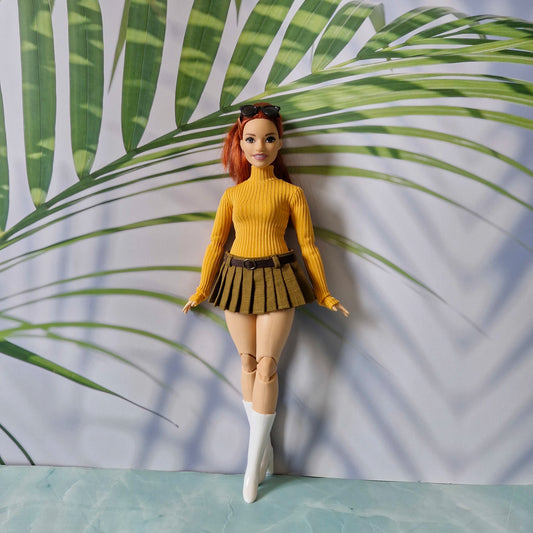 Redhead Curvy Barbie doll wearing a mustard yellow ribbed turtleneck sweater and olive green pleated mini skirt