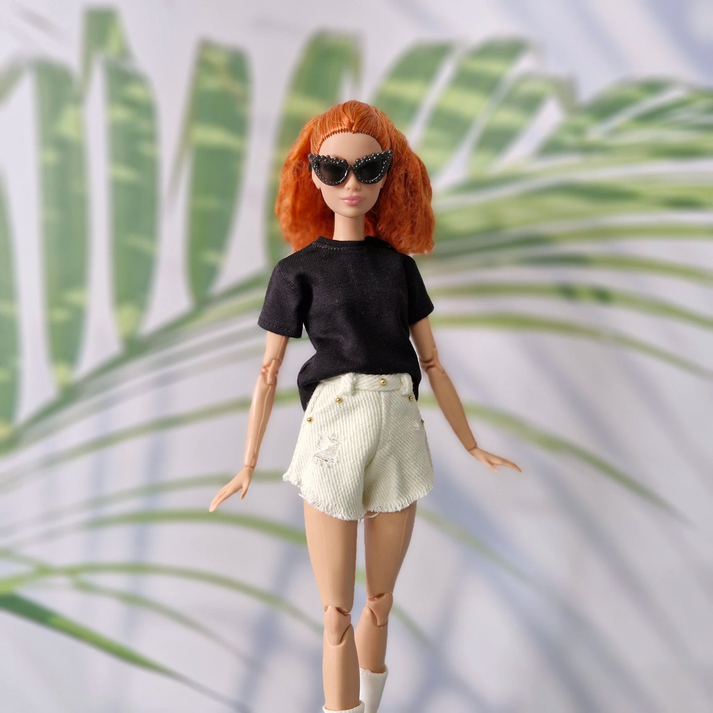 Redhead Barbie doll walking confidently in casual black t-shirt, white shorts, and black sunglasses