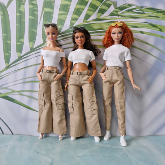 Three Barbie dolls in standard and curvy sizes wearing white tops and khaki pants