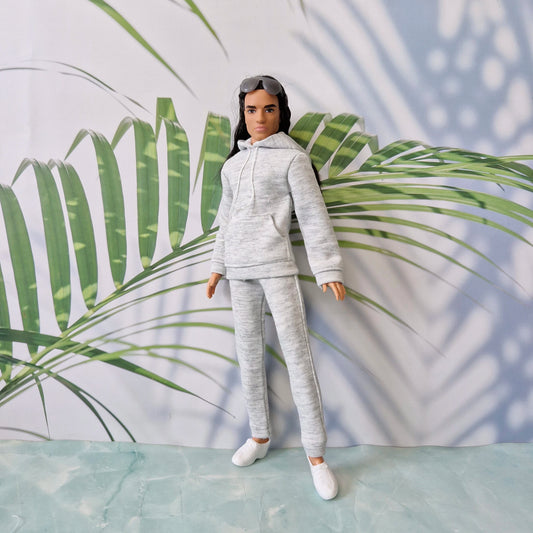 Detailed view of a Ken doll wearing a grey miniature sweatshirt and sweatpants, looking stylish and relaxed.