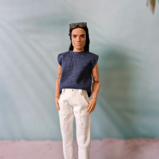 Ken doll modeling a casual navy blue sleeveless t-shirt and white distressed denim jeans.