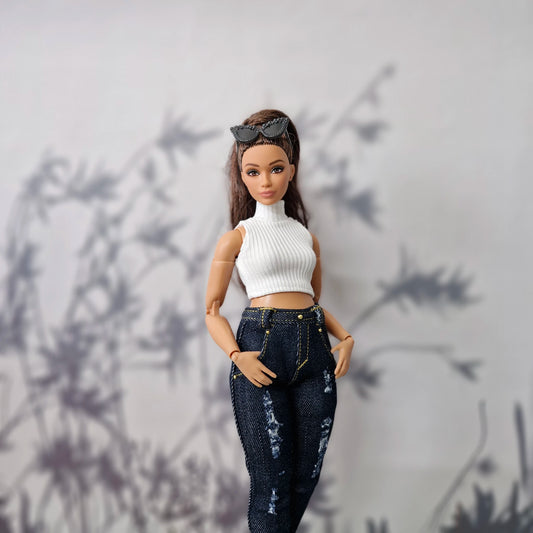 Close up of a brunette Curvy Barbie wearing a white high-neck top and dark blue distressed jeans.