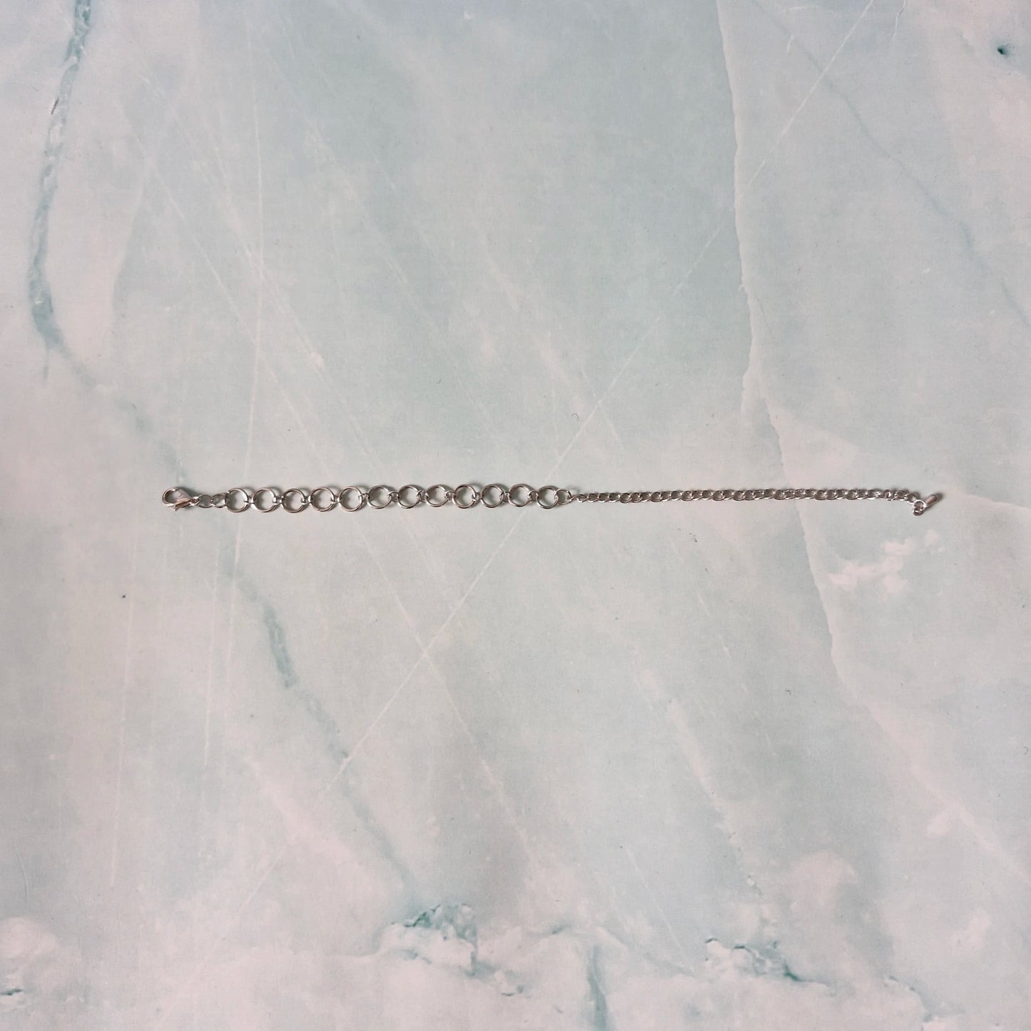 Silver chain bracelet on a marble surface