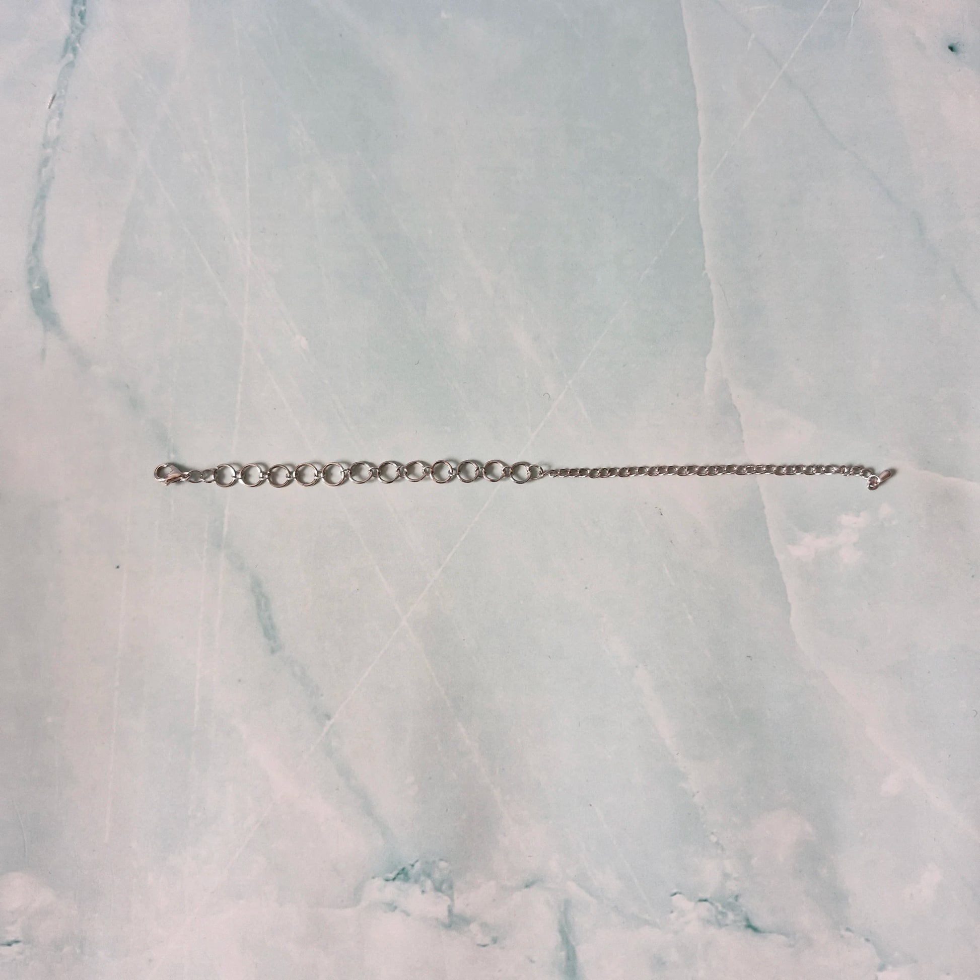 Silver chain bracelet on a marble surface