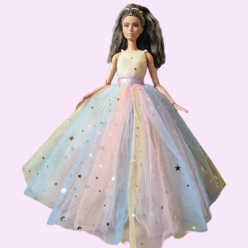 Barbie doll wearing a sleeveless cream-colored top and a voluminous rainbow tulle skirt decorated with gold and silver star patterns.