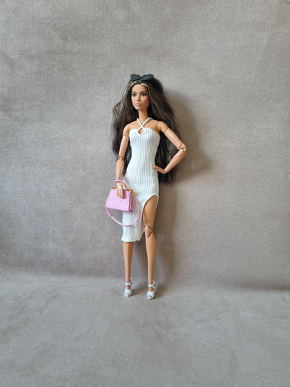 Barbie doll wearing white ribbed midi dress without sleeves, holding pink purse, sunglasses on head, white heels.