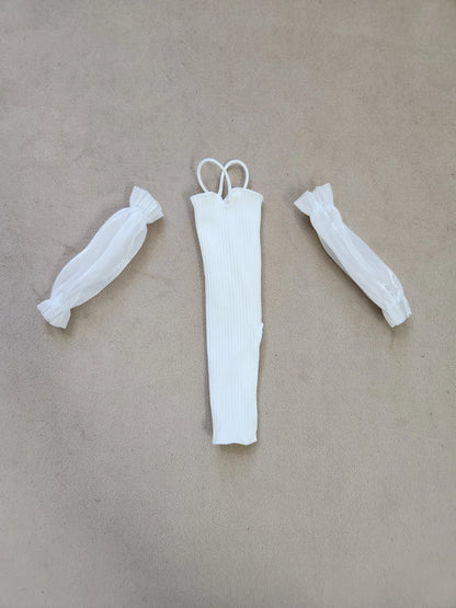 Barbie outfit components flat lay: white ribbed halter midi dress and separate sheer white puff sleeves on beige background.