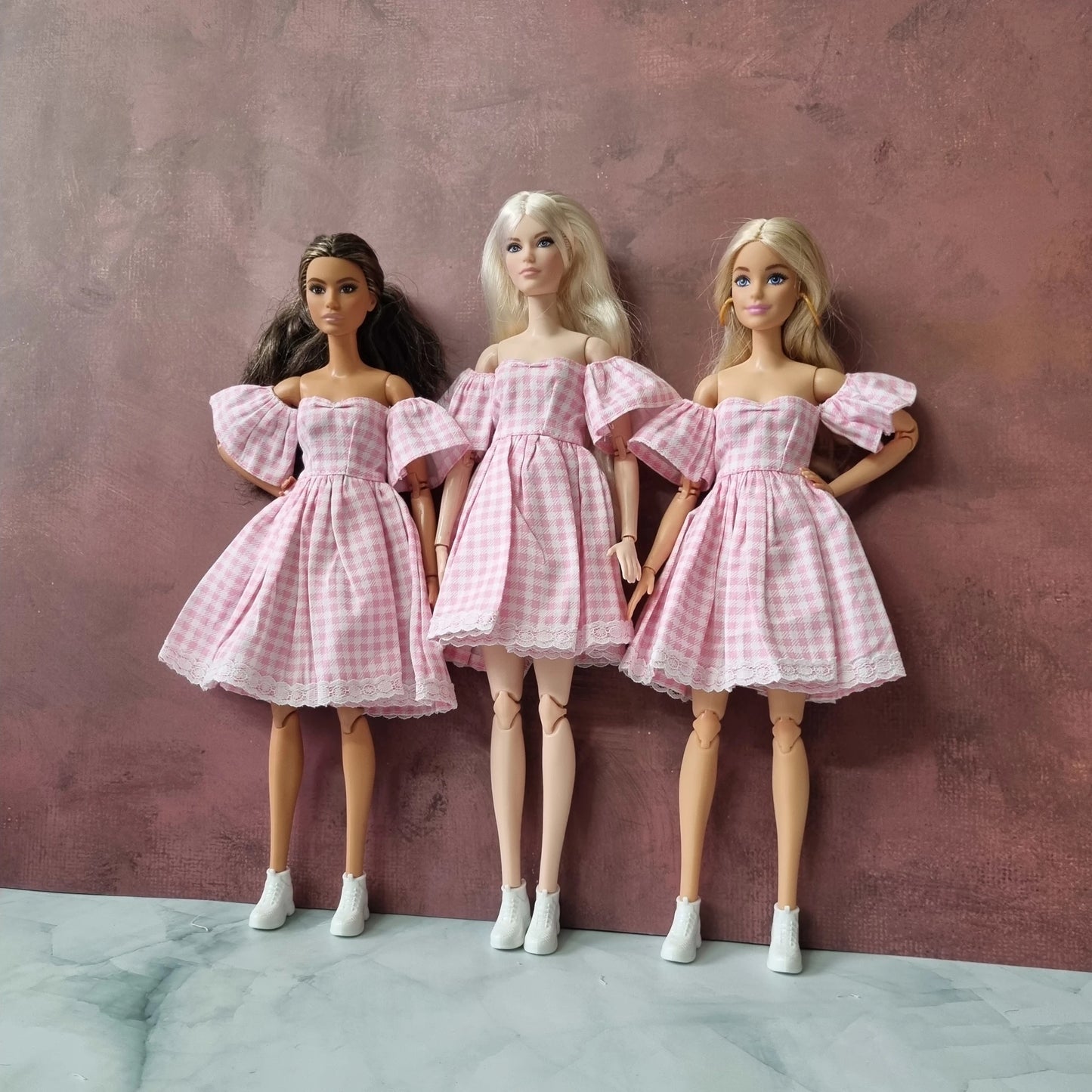 Barbie dolls dressed in retro pink gingham dresses posing together