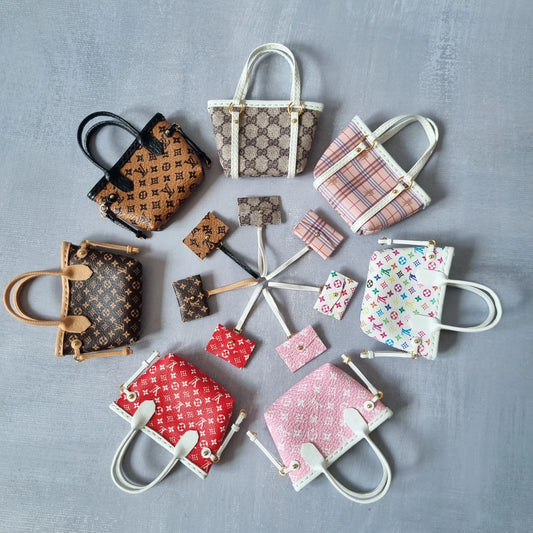 Flat lay of eight different designer-inspired miniature tote bags for dolls with matching pouches.