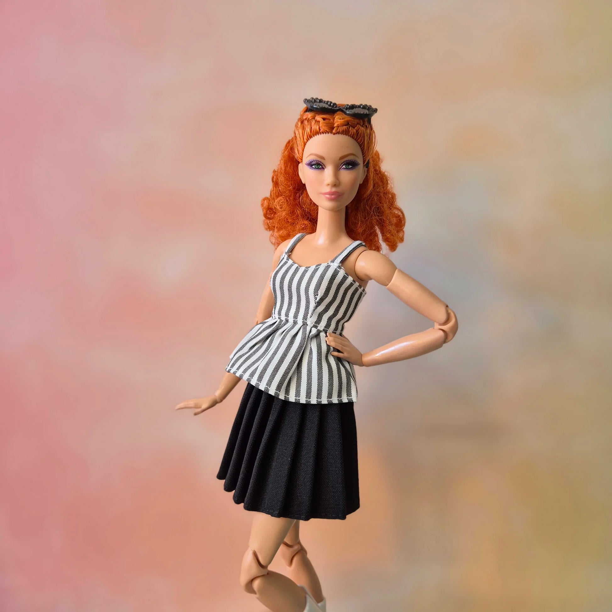 Fashionable dark-skinned Barbie doll modeling blue gingham top and peach plaid pleated skirt.
