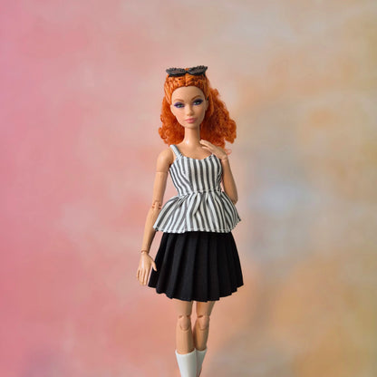 Red-haired Barbie doll in black & white striped peplum top and black pleated skirt.