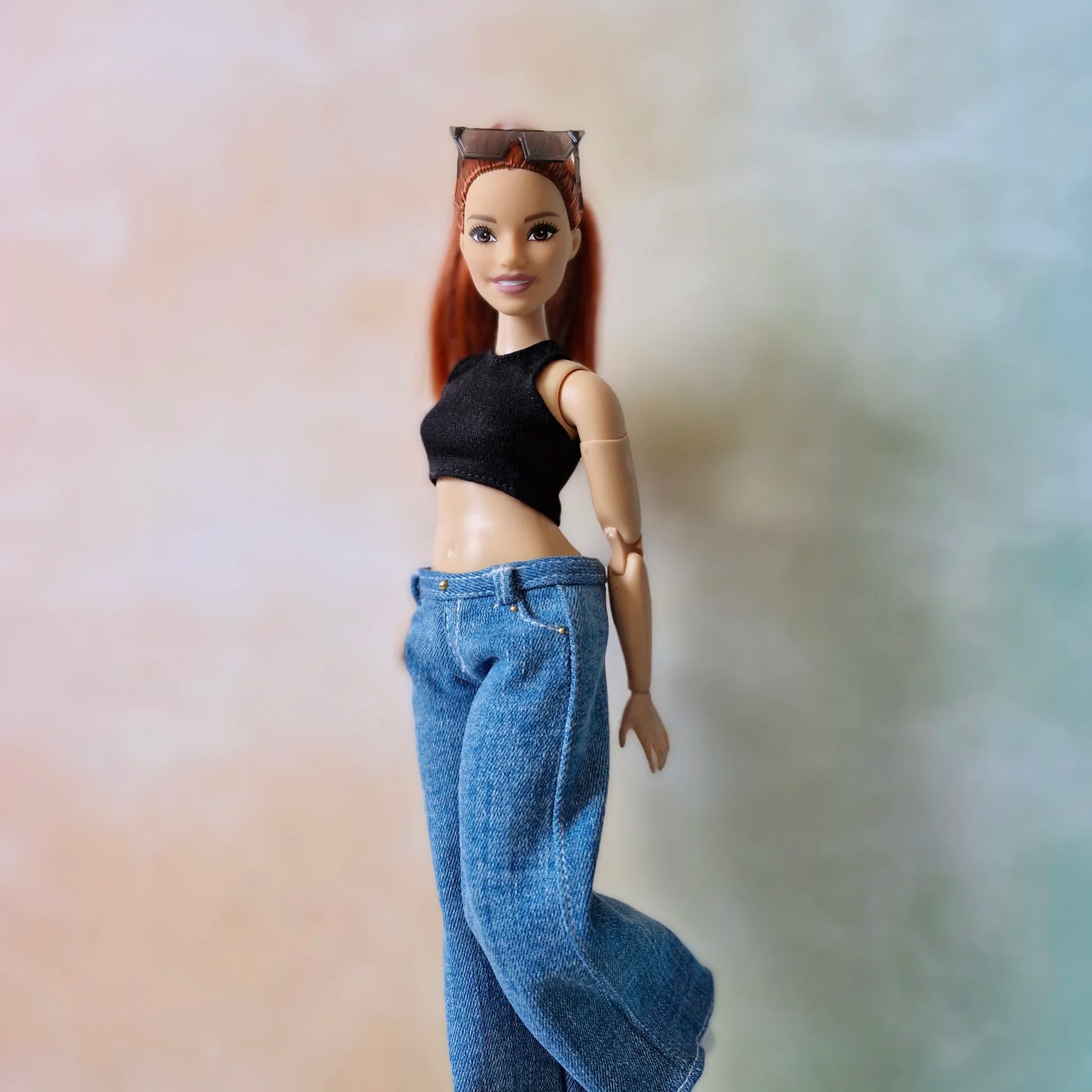 Redhead Curvy Barbie doll in black top and wide-leg jeans walking pose