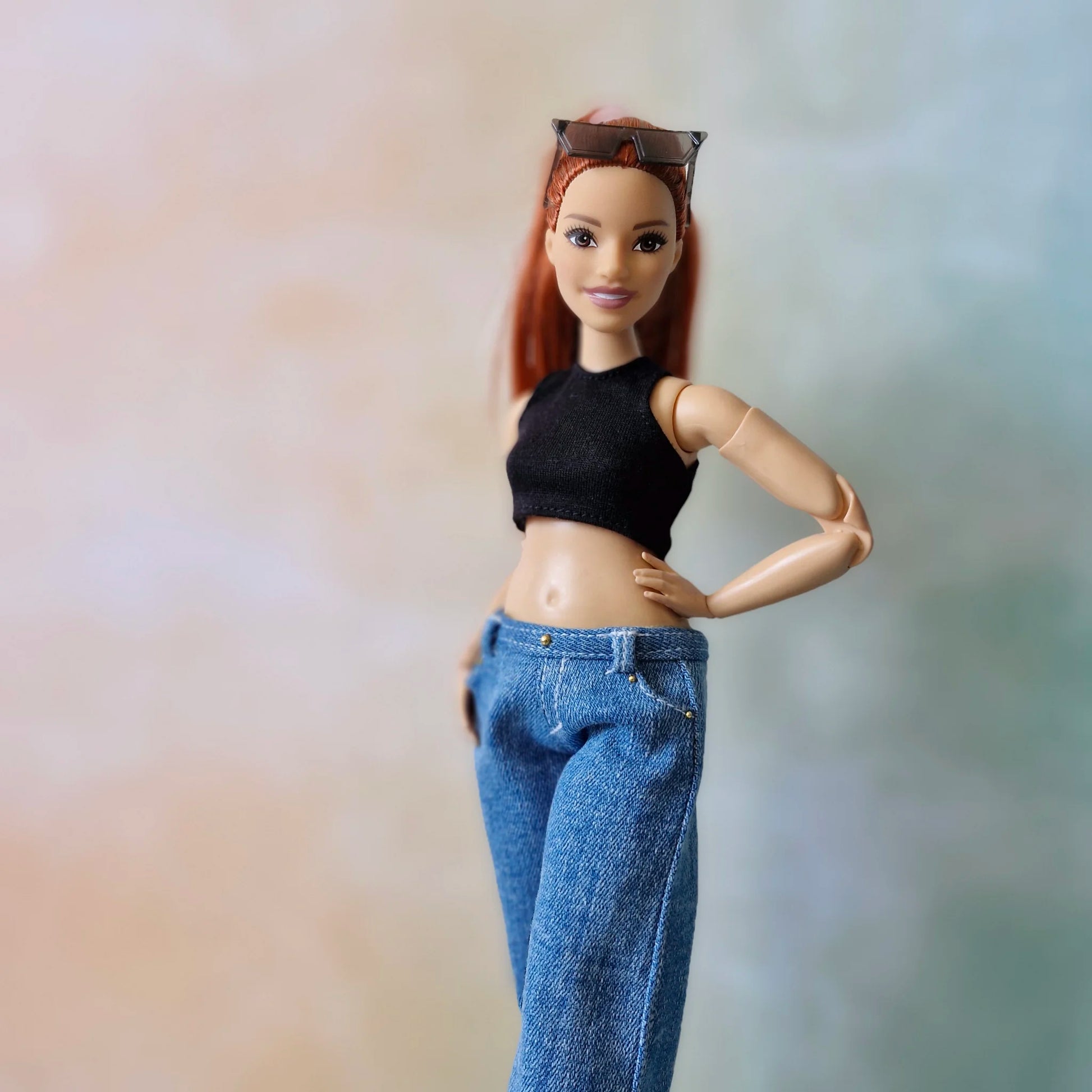 Redhead Curvy Barbie doll in black crop top and wide-leg blue jeans, hand on hip pose