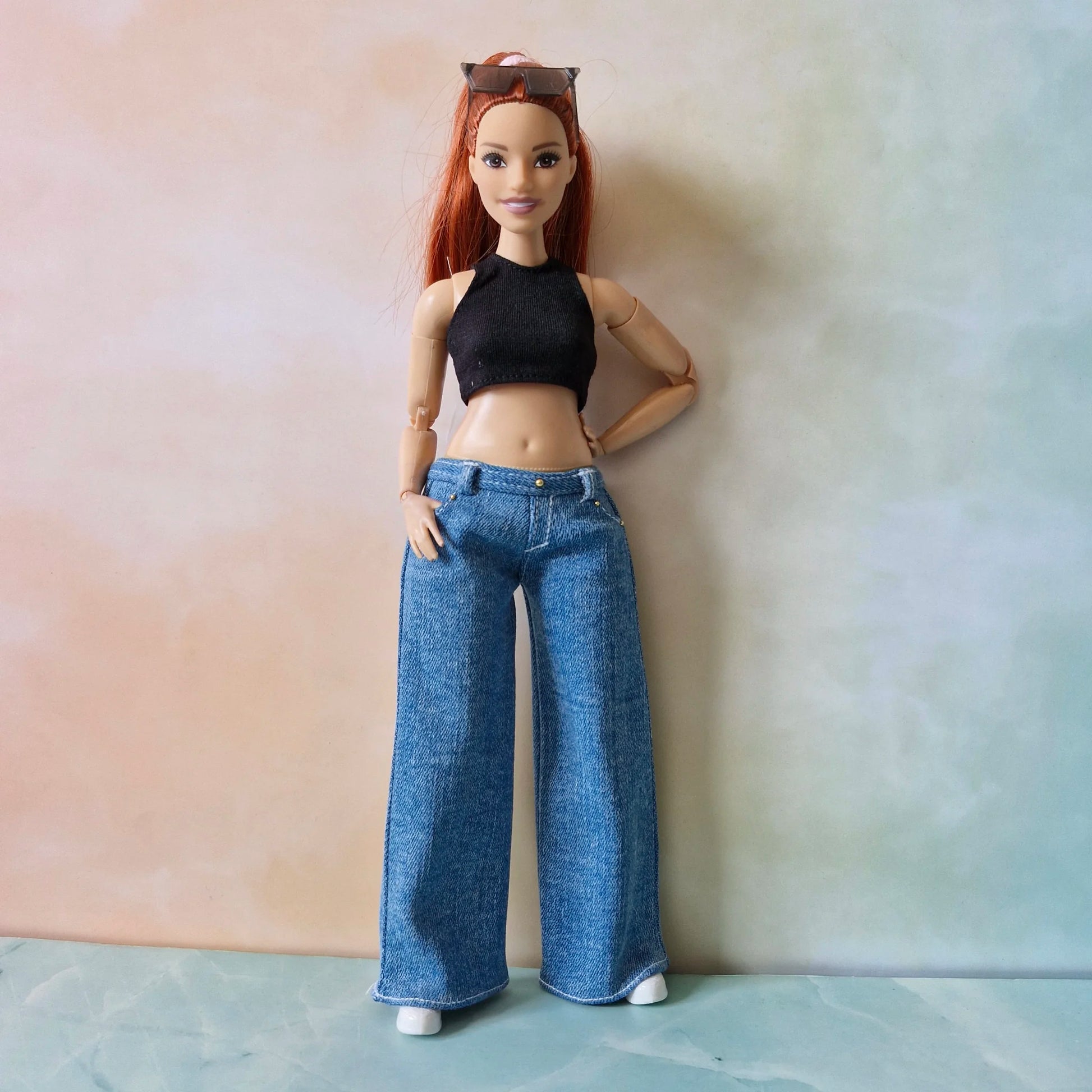 Full length view of redhead Curvy Barbie doll wearing black crop top and wide-leg denim jeans
