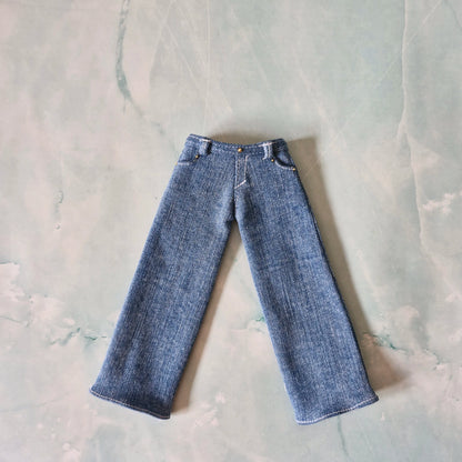 Flat lay view of wide-leg blue denim jeans for Curvy Barbie dolls with pocket details