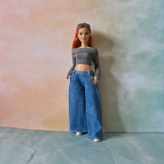 Full length redhead Curvy Barbie doll wearing grey crop top and wide-leg blue jeans