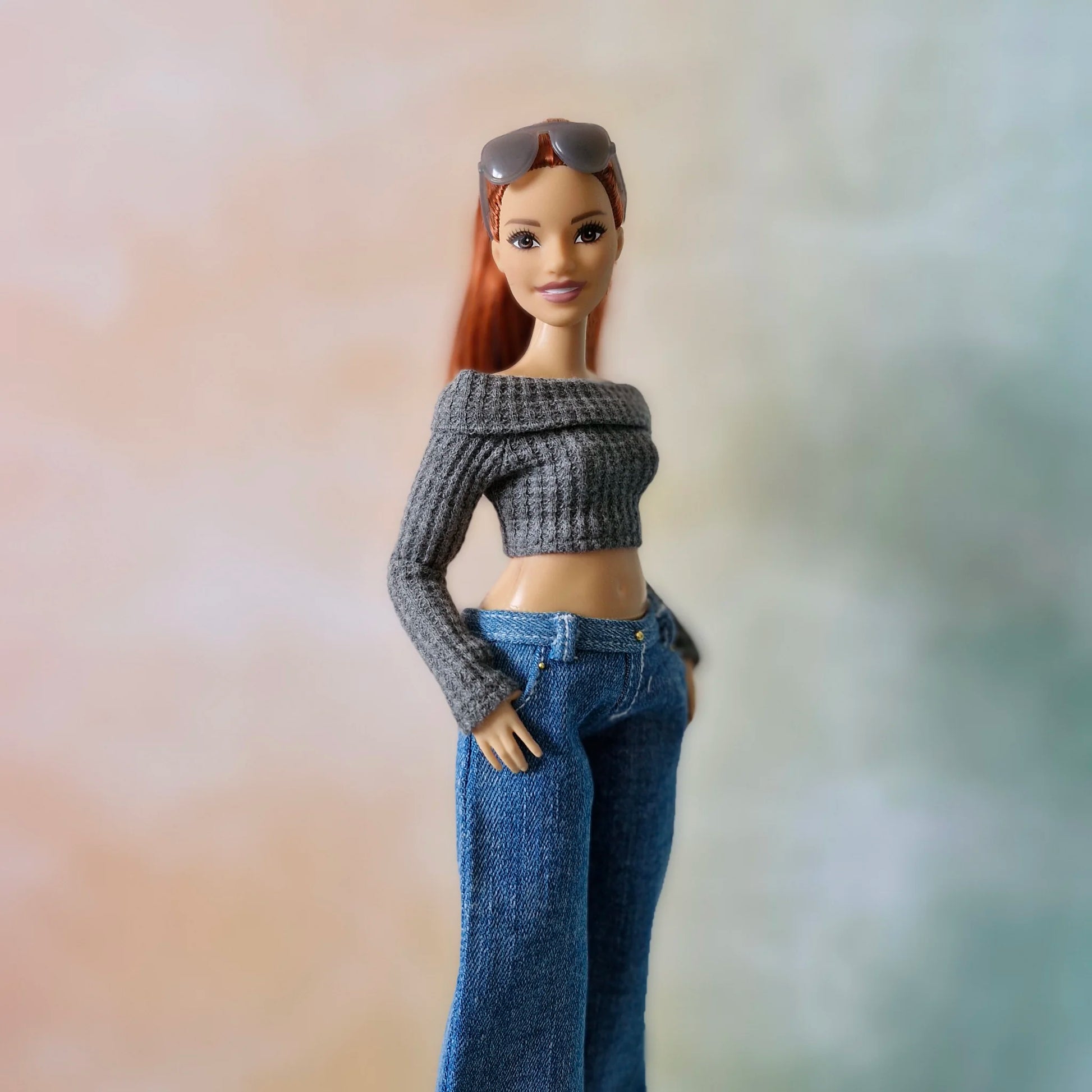 Redhead Curvy Barbie doll models grey crop top and wide-leg jeans with hands in pockets