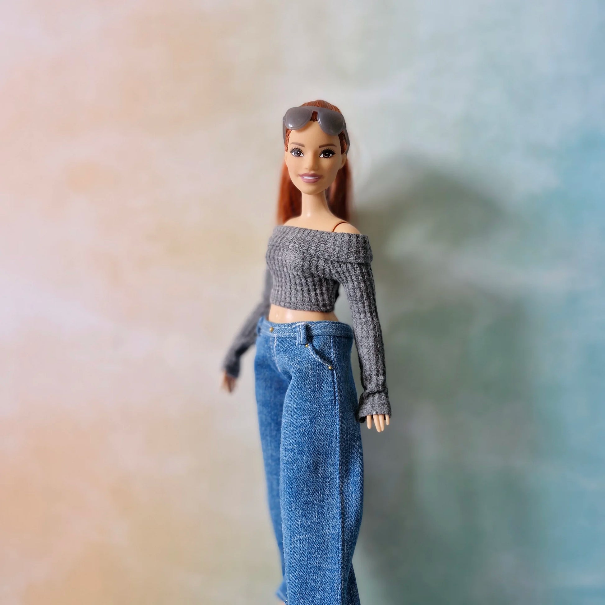 Redhead Curvy Barbie doll in grey off-shoulder top and wide-leg denim jeans, side angle