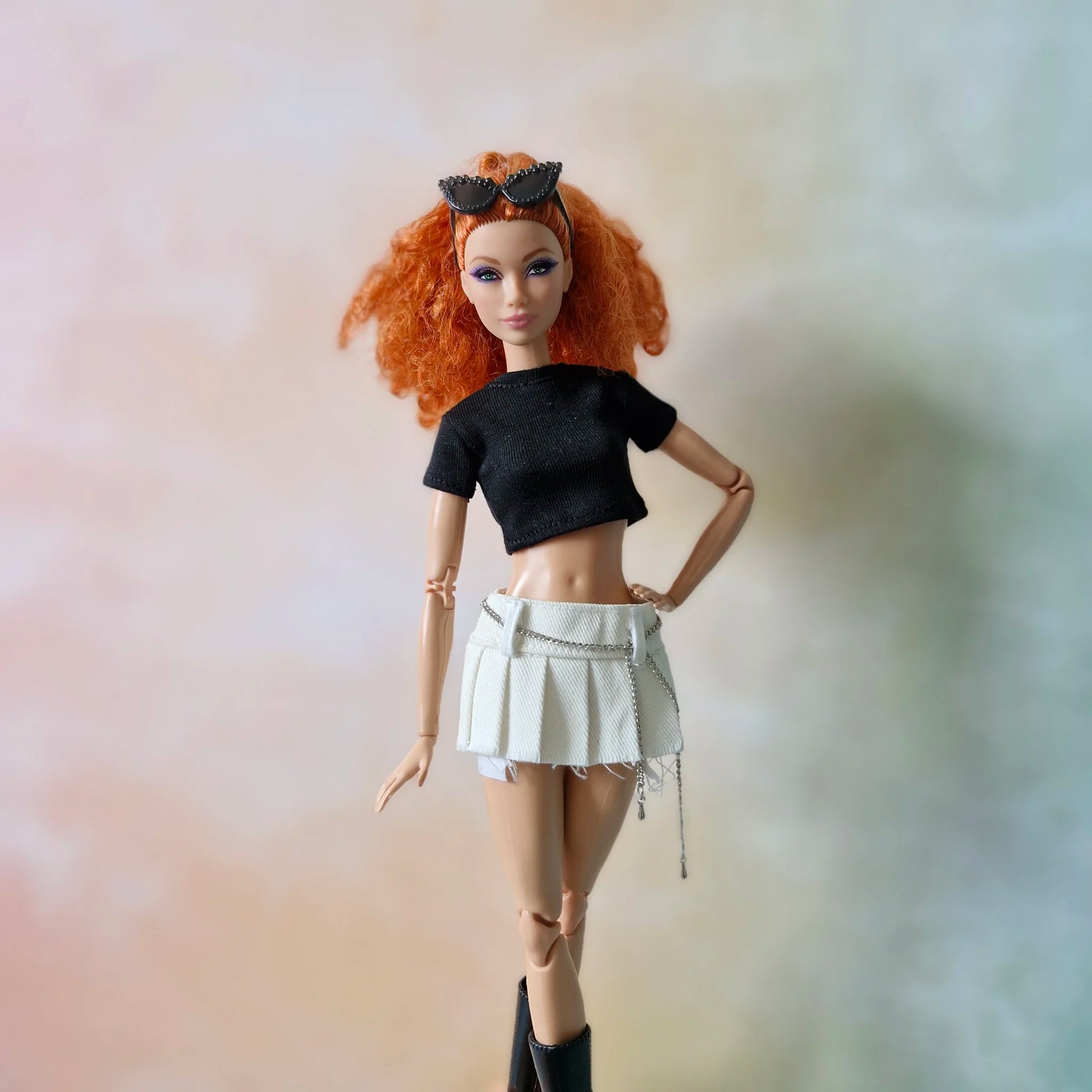 Redhead doll wearing black crop top and white denim pleated mini skirt with chain detail