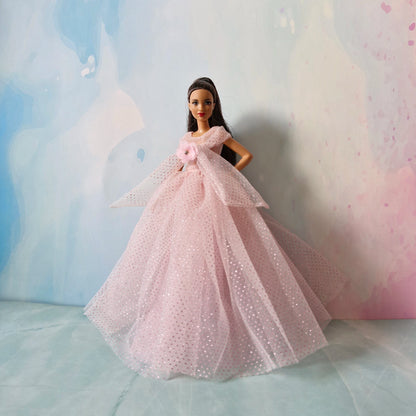Full length view of Barbie doll wearing elegant pink sparkly tulle ball gown dress.