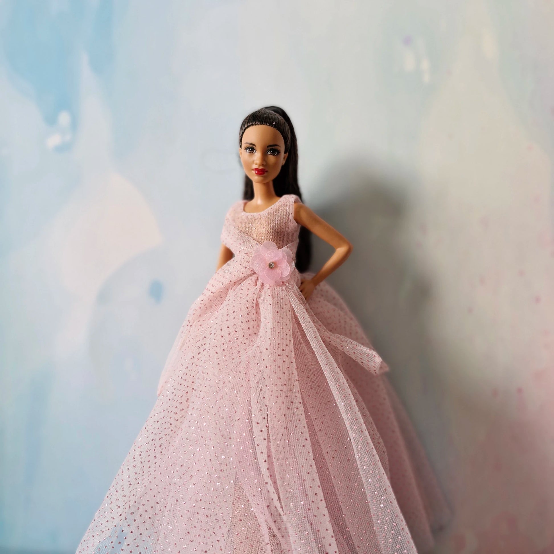 Barbie doll modeling elegant pink glitter tulle ball gown, medium shot front view.