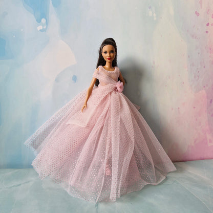 Barbie doll standing elegantly in beautiful pink sparkly tulle ball gown, full view.