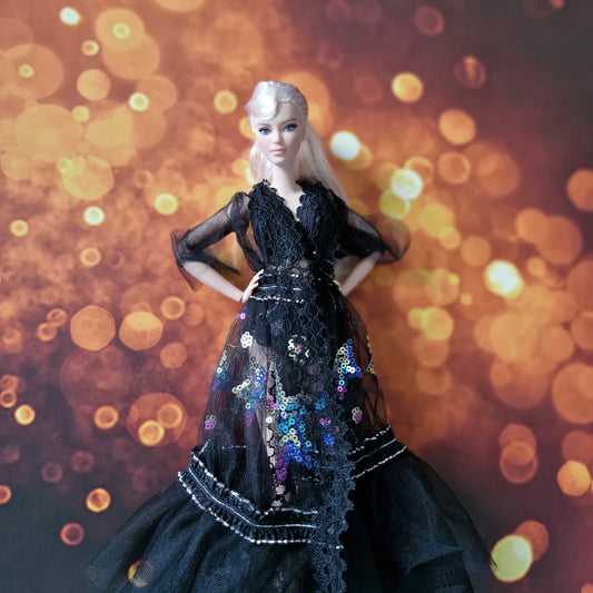 Front view of blonde Barbie doll in dramatic black sheer lace and sequin evening gown.