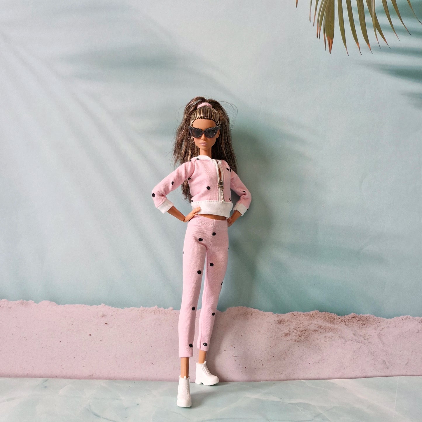Barbie doll posing confidently in pink polka dot tracksuit and sunglasses.